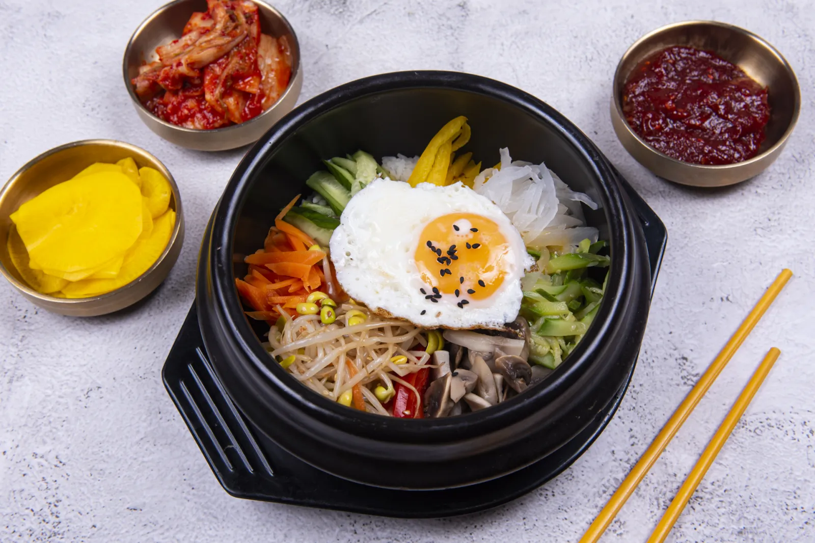 Beef bibimbap in a hot stone bowl with a fried egg